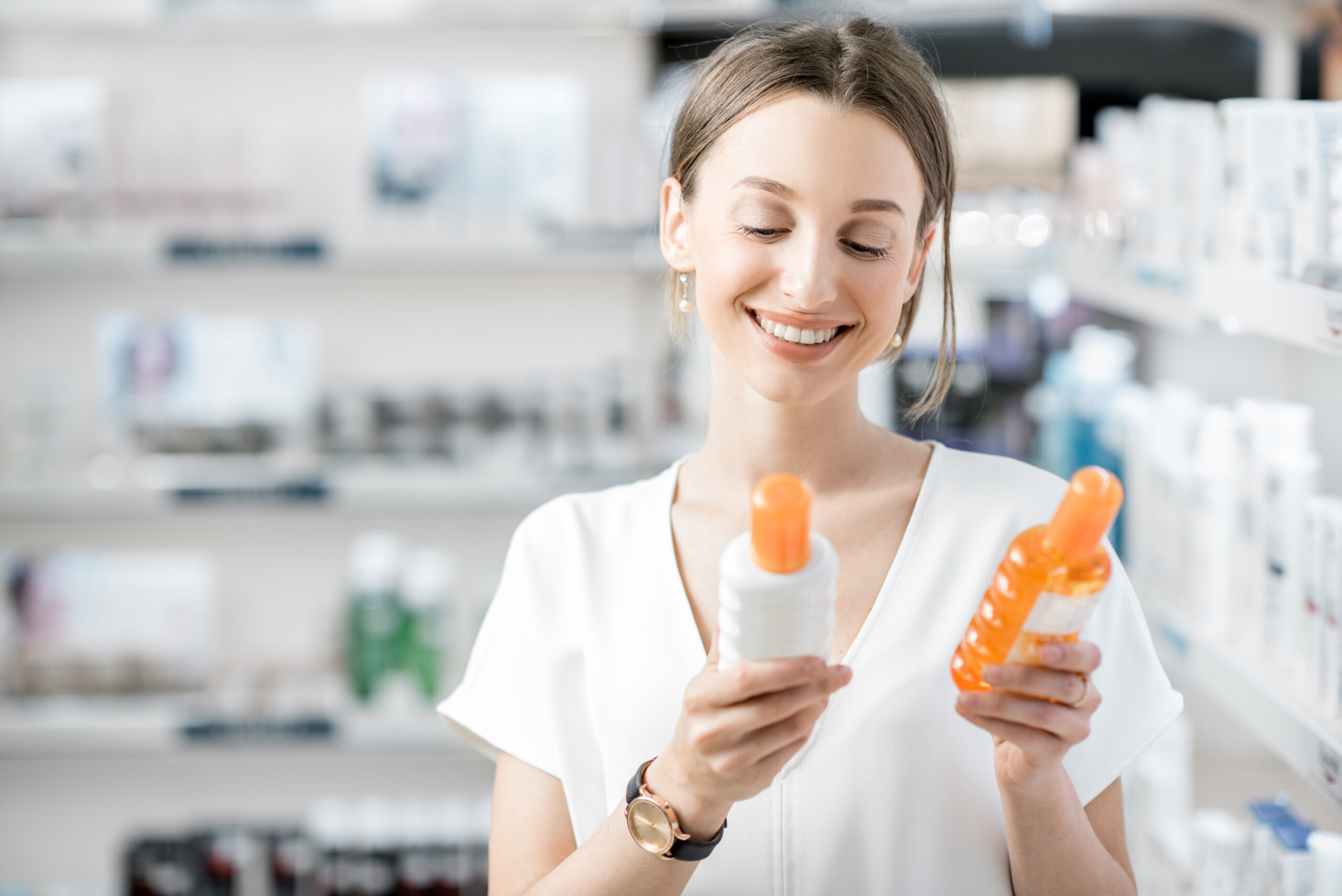 Le patient choisit une crème solaire en pharmacie.