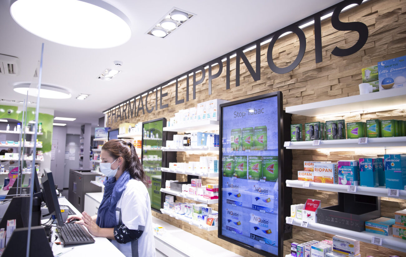 Pharmacien aide un patient au comptoir